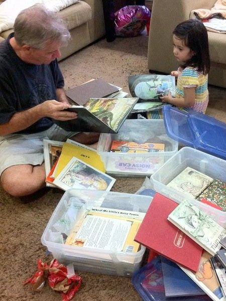 Alba sitting looking at books with dad