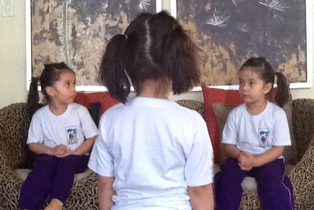 Triple exposure of Alba in her kindergarten uniform, three overlapping portraits each looking at the others