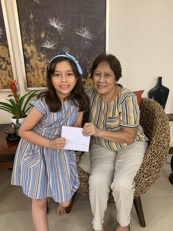 Alba handing her grandmother a greeting card