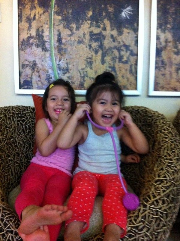 Alab and Rielle as toddlers sitting together on a chair