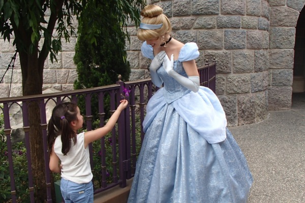 Alba is handing a small flower to Cinderella at Hong Kong Disney Land