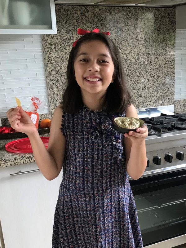 Alba has a great big smile as she eats a s spinach dip