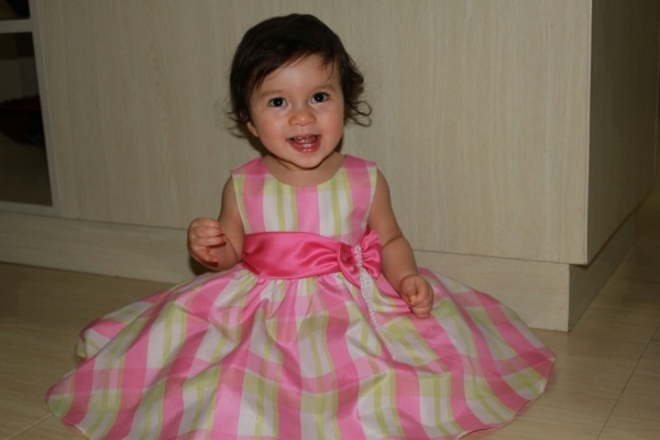 Alba sitting on he floor in a pink dress